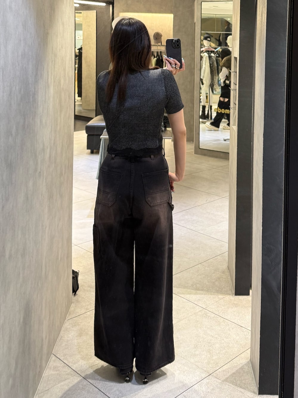 ブラック系のニット/セーター、ブラック系のデニムパンツ、ブラック系のスニーカーを着用したレディースの春コーディネートの3枚目の写真