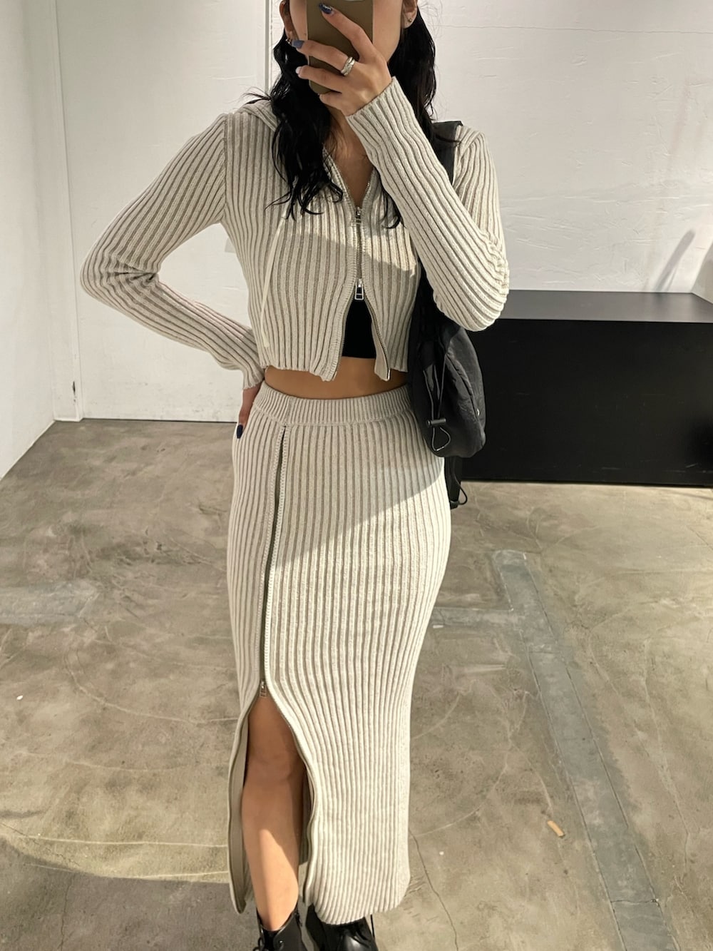 ホワイト系のワンピース、ブラック系のキャミソール、ブラック系のブーツを着用したレディースの春コーディネートの5枚目の写真