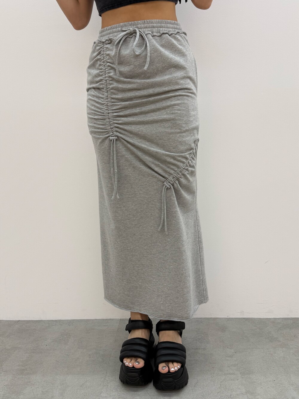 ホワイト系のTシャツ/カットソー、グレー系のスカート、ブラック系のサンダルを着用したレディースの夏コーディネートの7枚目の写真