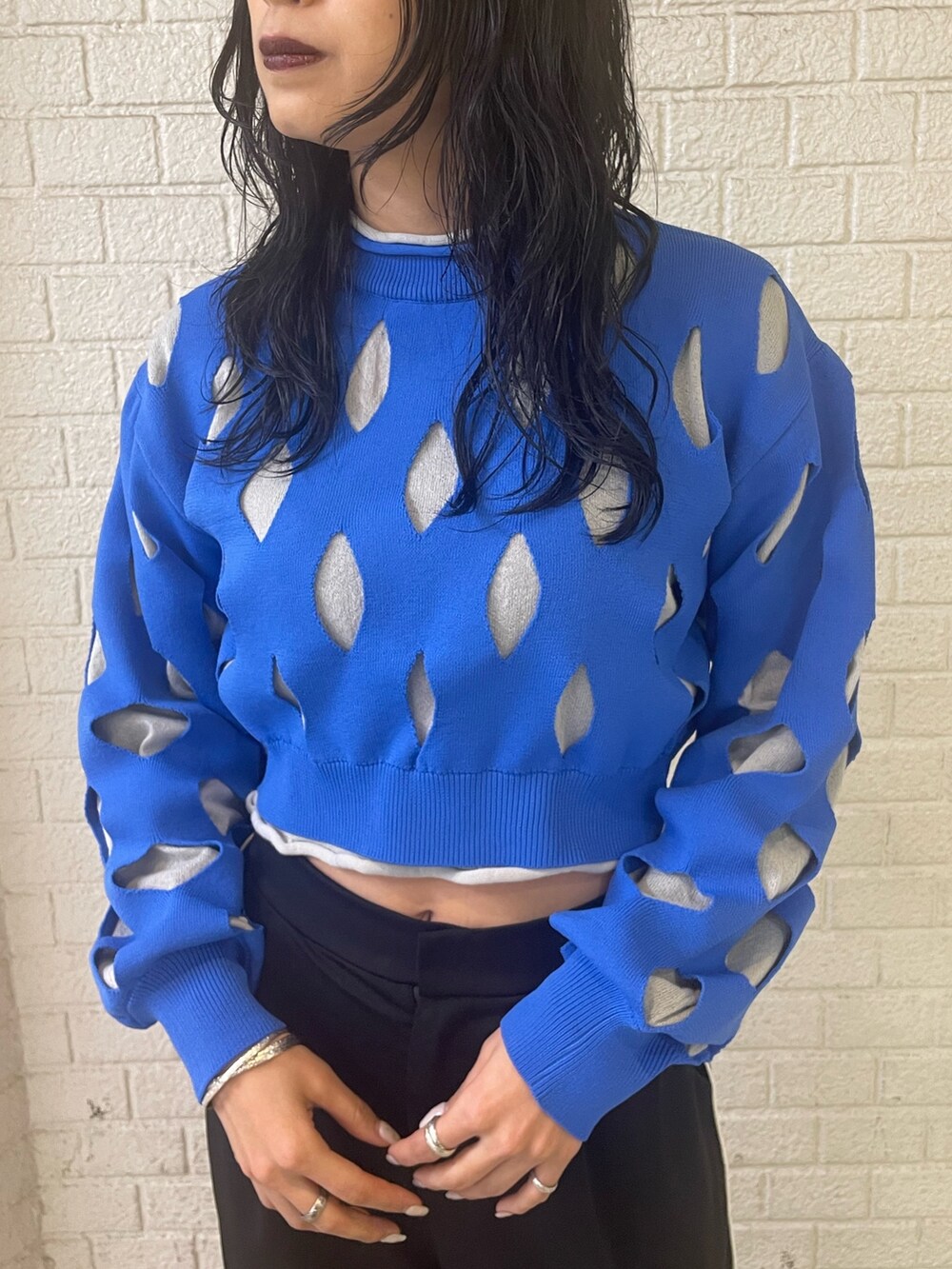 ブルー系のニット/セーター、ブラック系のスラックス、ブラック系のローファーを着用したレディースの冬コーディネートの4枚目の写真