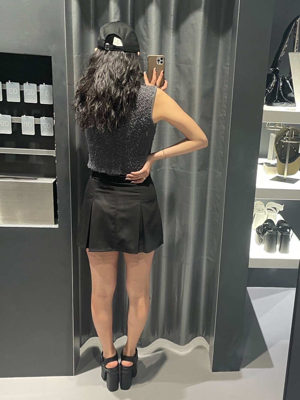 グレー系のタンクトップ、ブラック系のスカート、ブラック系のサンダルを着用したレディースの夏コーディネートの3枚目の写真