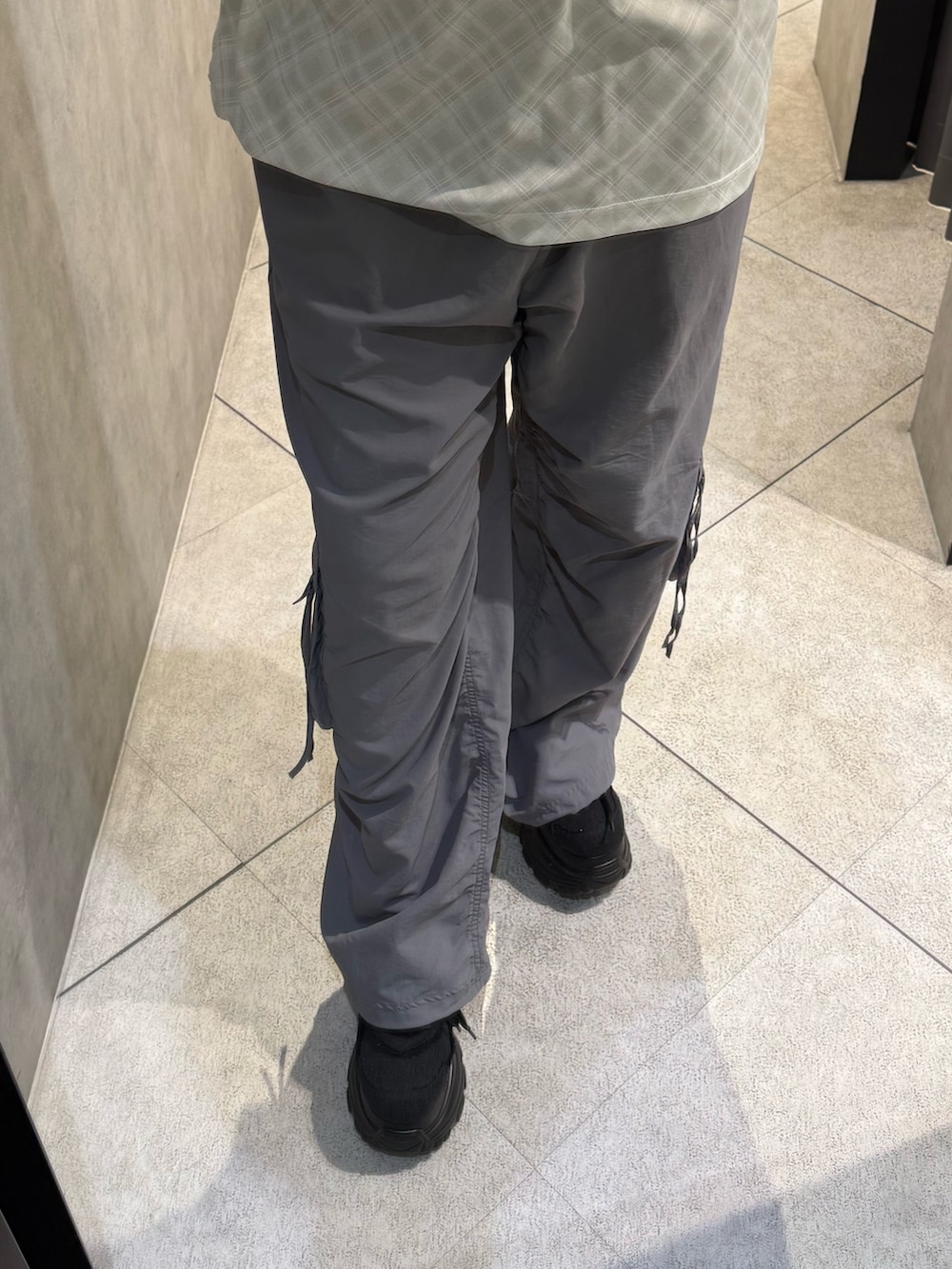 ホワイト系のTシャツ/カットソー、グレー系のその他パンツ、ブラック系のスニーカーを着用したレディースの春コーディネートの4枚目の写真