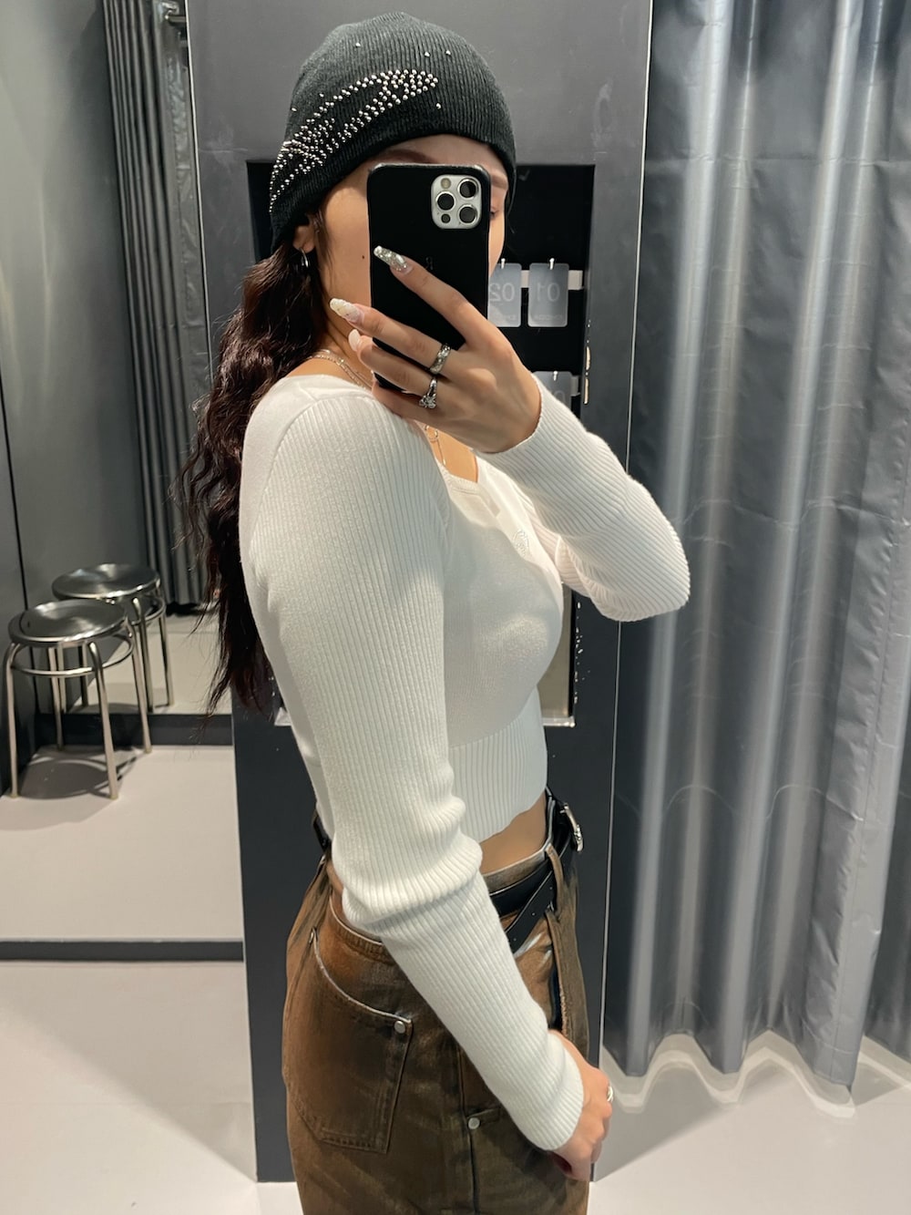 ホワイト系のニット/セーター、ブラウン系のデニムパンツ、ブラック系のブーツを着用したレディースの冬コーディネートの7枚目の写真