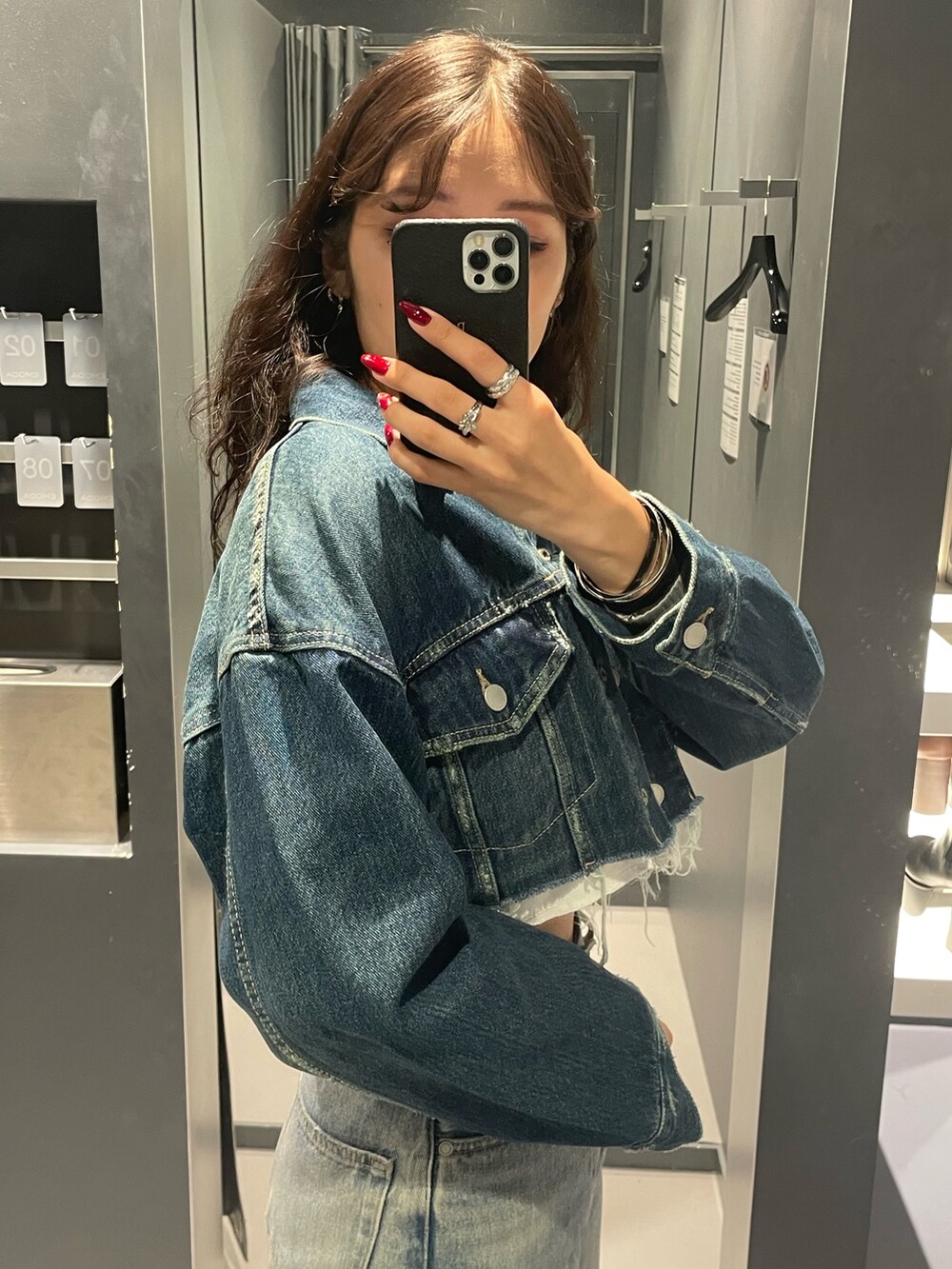 ブルー系のデニムジャケット、ブラック系のワンピース、イエロー系のハンドバッグを着用したレディースの秋コーディネートの9枚目の写真