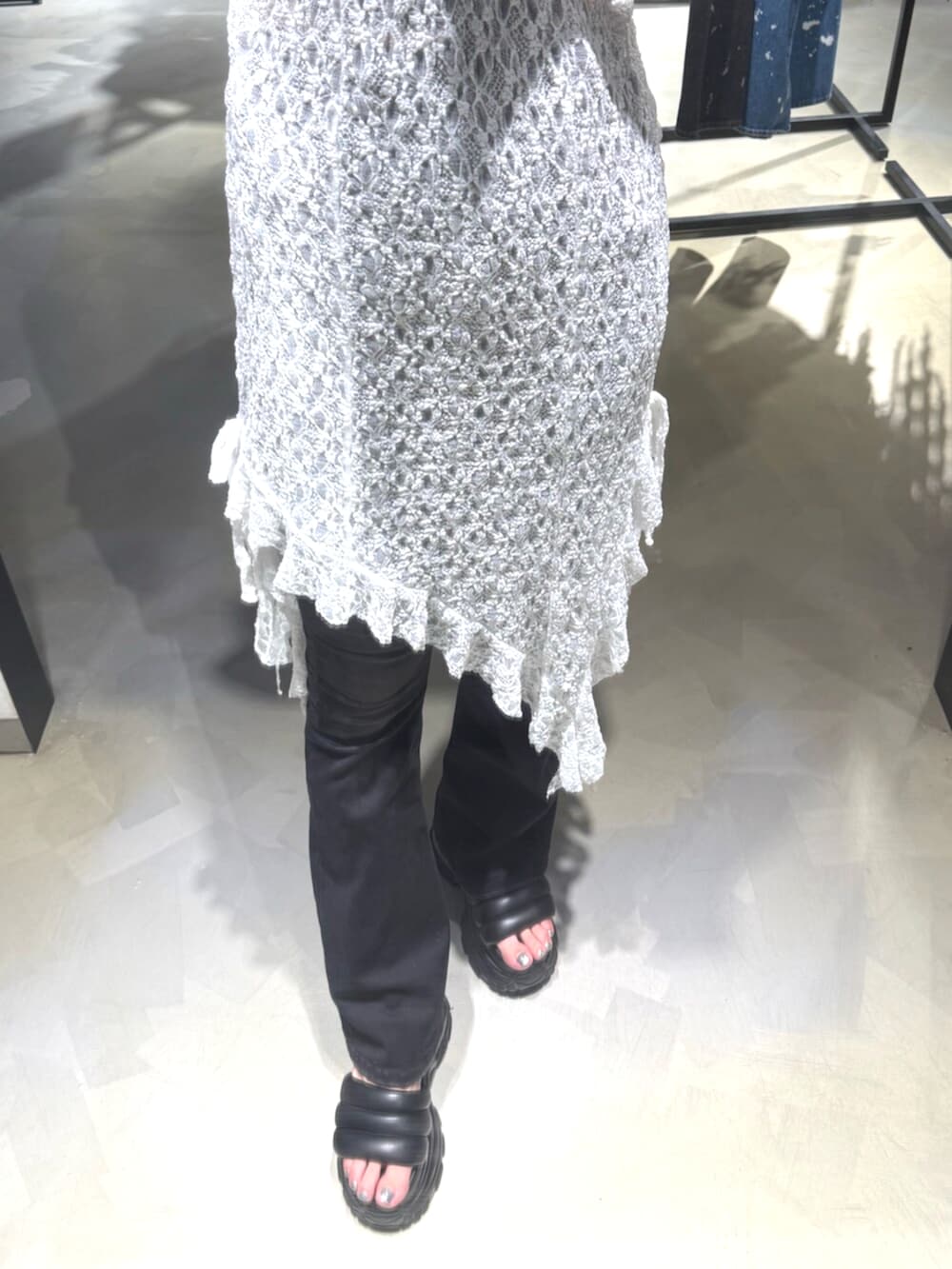 ブラック系のデニムパンツ、ブラック系のニット/セーター、ブラック系のサンダルを着用したレディースの夏コーディネートの6枚目の写真