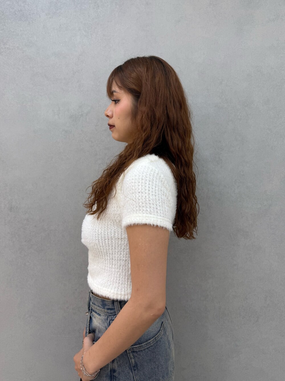 ホワイト系のTシャツ/カットソー、ブルー系のデニムパンツ、ブラック系のハンドバッグを着用したレディースの夏コーディネートの5枚目の写真