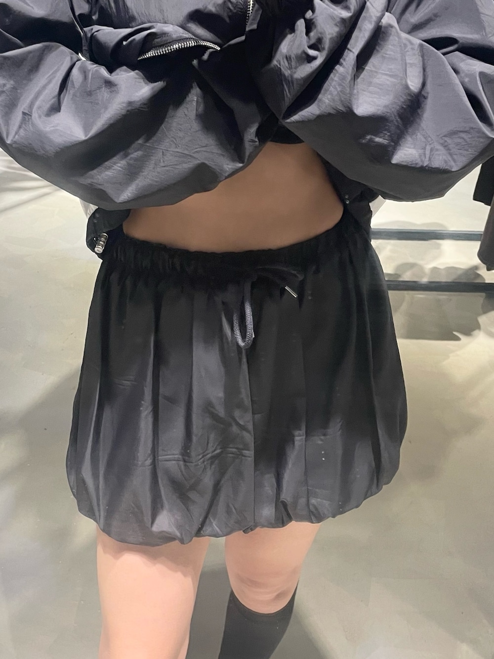 「EMODA、モノトーン、モノトーンコーデ、ブラックコーデ、高身長女子、高身長コーデ、骨格ストレート、春コーデ、キャミソール、ナイロンジャケット、バルーンスカート、ミニスカート、ニーハイソックス、スニーカーサンダル、厚底シューズ」｜「EMODAのフックモチーフネックレス（ネックレス、シルバー系）」を使った、菅谷レイナさん（レディース・168cm）の春コーディネートの6枚目の写真