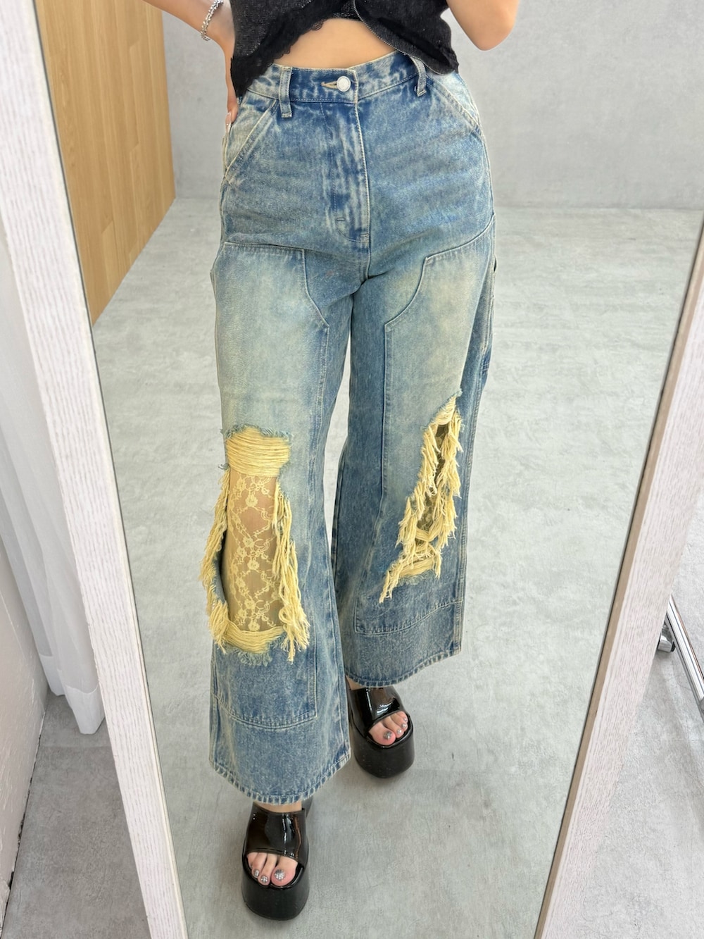 ブラック系のサンダル、ブルー系のデニムパンツ、ブラック系のニット/セーターを着用したレディースの春コーディネートの5枚目の写真
