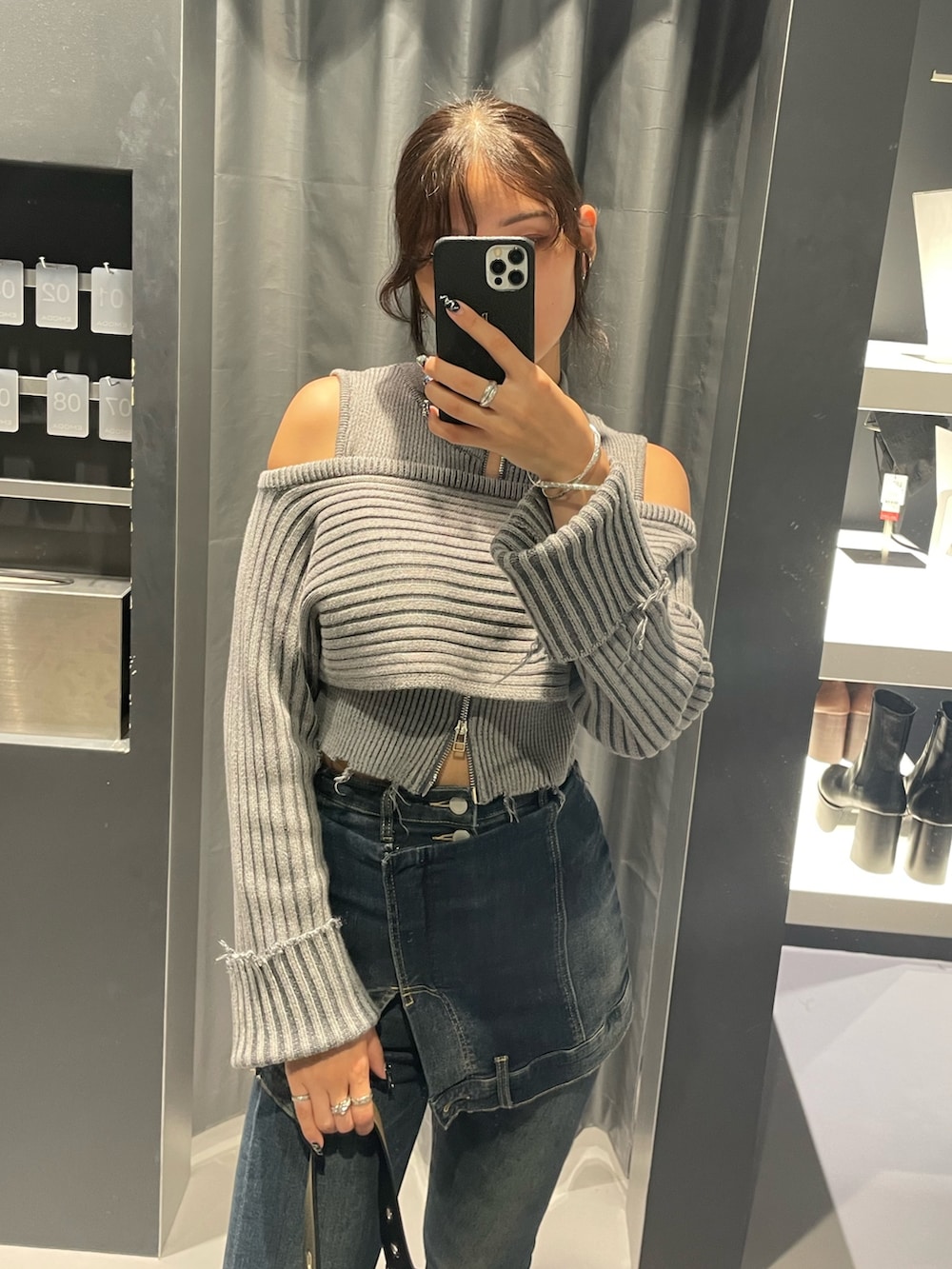 グレー系のニット/セーター、ブルー系のデニムパンツ、ブラック系のハンドバッグを着用したレディースの秋コーディネートの4枚目の写真