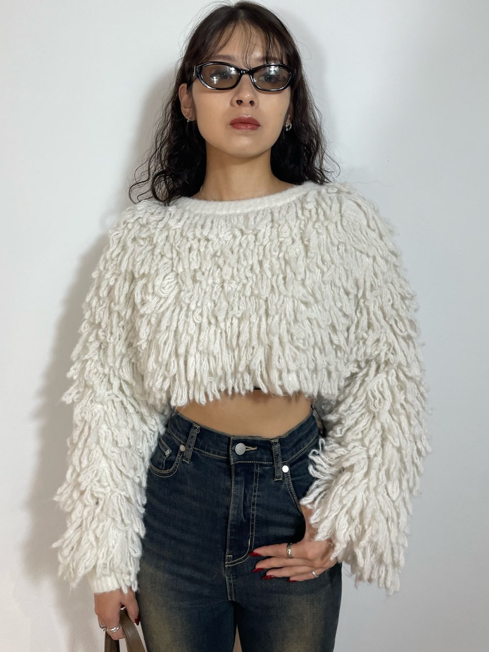 ホワイト系のニット/セーター、ブラック系のスカート、ブラック系のブーツを着用したレディースの秋コーディネートの4枚目の写真