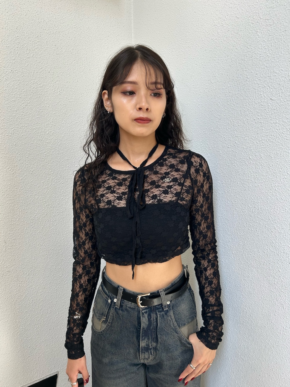 ブラック系のTシャツ/カットソー、ブラック系のキャミソール、ブルー系のデニムパンツを着用したレディースの秋コーディネートの4枚目の写真