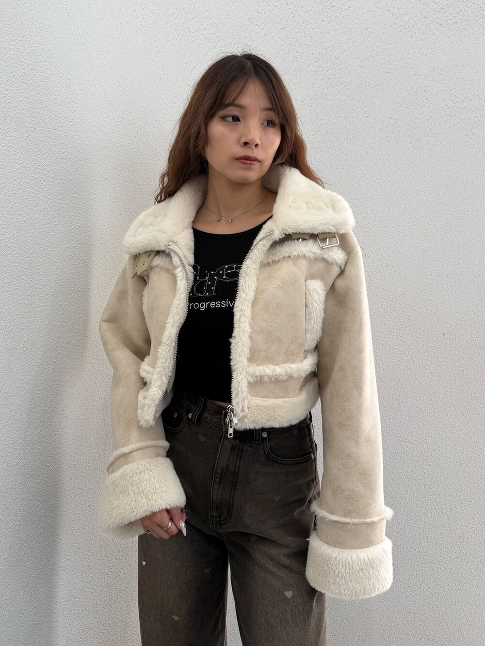 ホワイト系のブルゾン、ブラック系のTシャツ/カットソー、ブラウン系のデニムパンツを着用したレディースの秋コーディネートの4枚目の写真