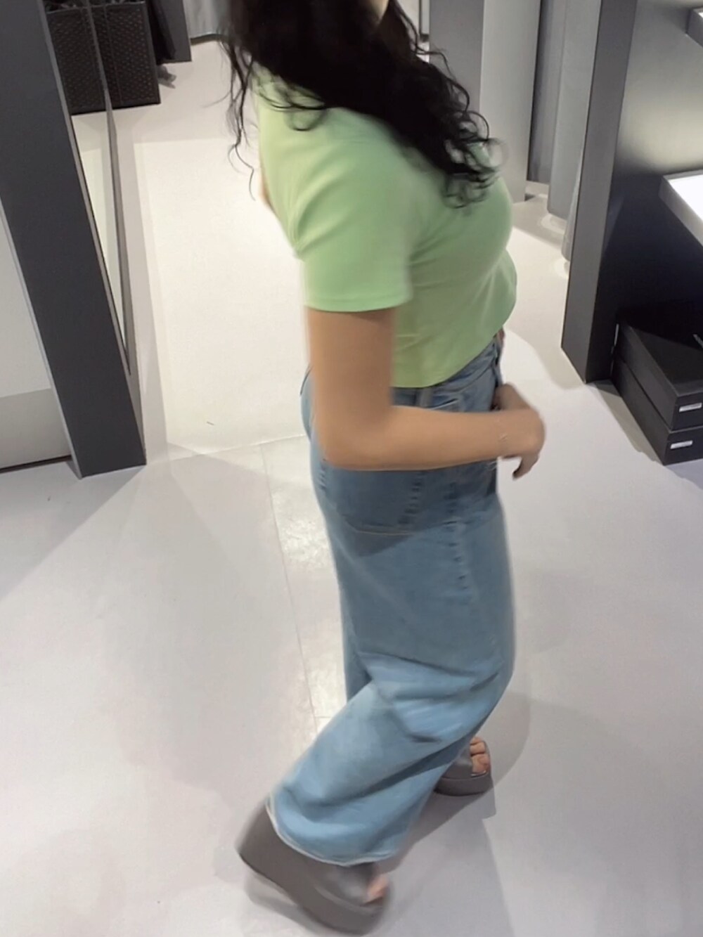 グリーン系のTシャツ/カットソー、ブルー系のデニムパンツ、シルバー系のサンダルを着用したレディースの春コーディネートの2枚目の写真