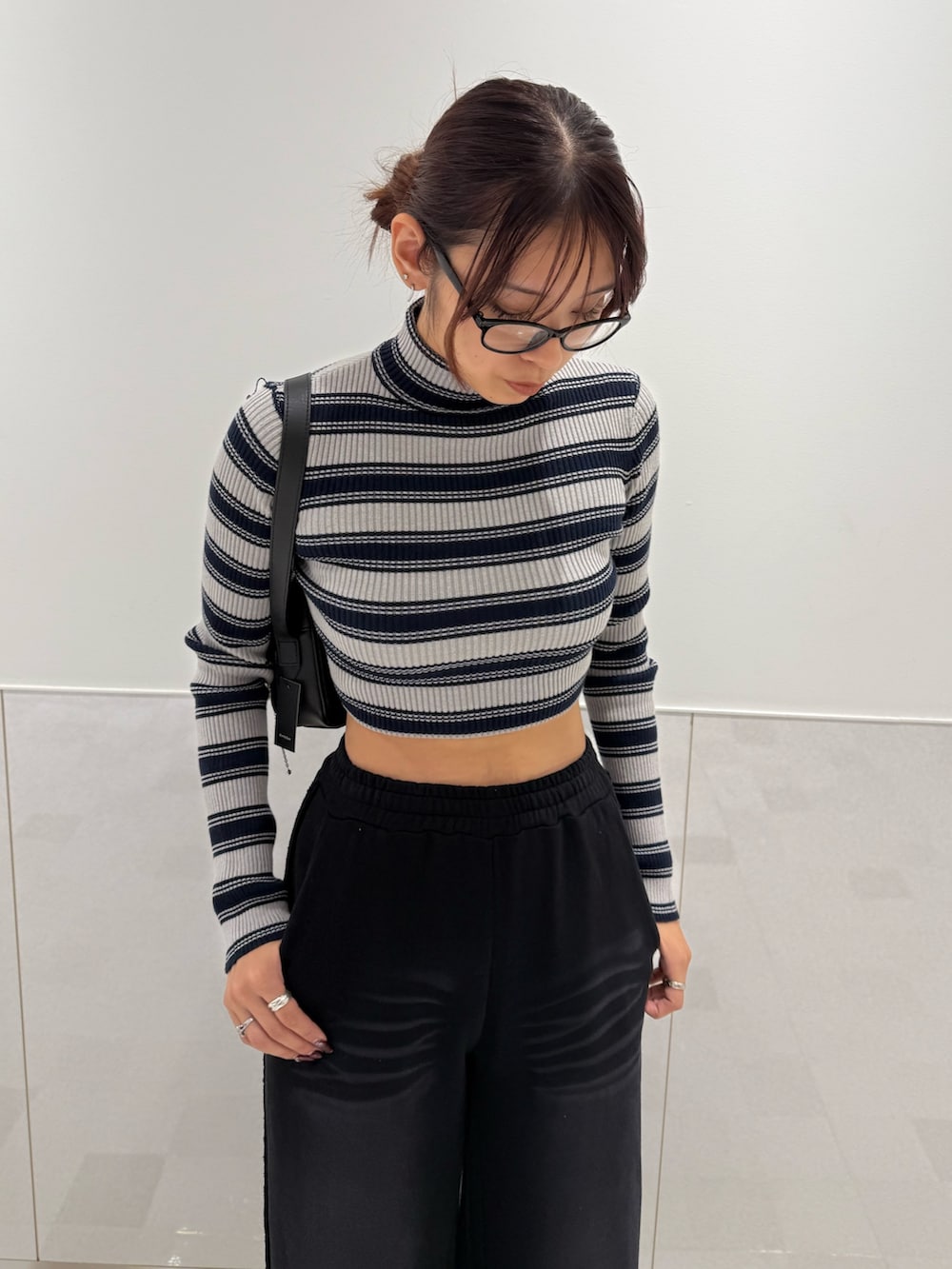 グレー系のニット/セーター、ブラック系のスウェットパンツ、ブラック系のブーツを着用したレディースの秋コーディネートの4枚目の写真