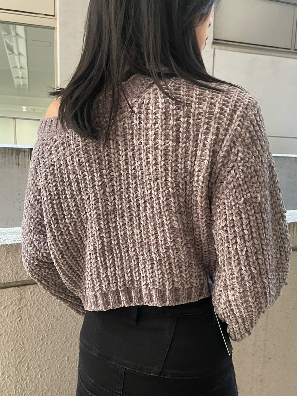 グレー系のニット/セーター、ブラック系のハンドバッグ、ブラック系のデニムパンツを着用したレディースの冬コーディネートの6枚目の写真