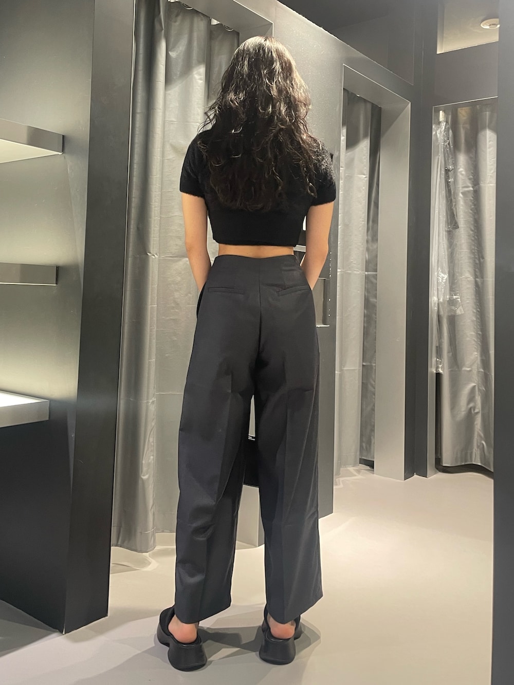 ブラック系のニット/セーター、グレー系のその他パンツ、ブラック系のショルダーバッグを着用したレディースの夏コーディネートの3枚目の写真