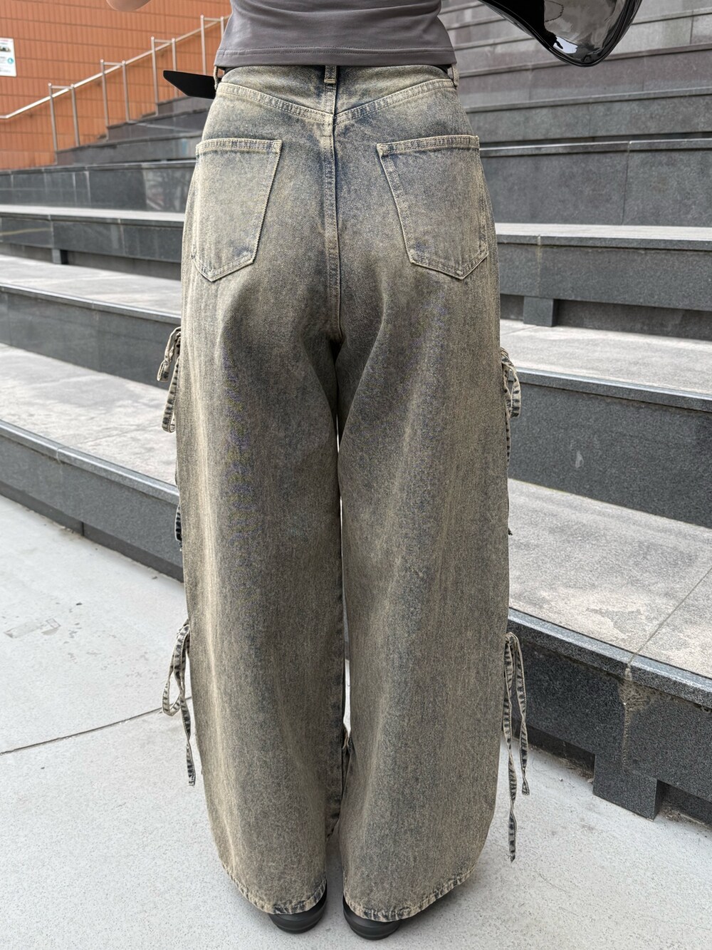 グレー系のTシャツ/カットソー、ブルー系のデニムパンツ、ブラック系のショルダーバッグを着用したレディースの春コーディネートの9枚目の写真