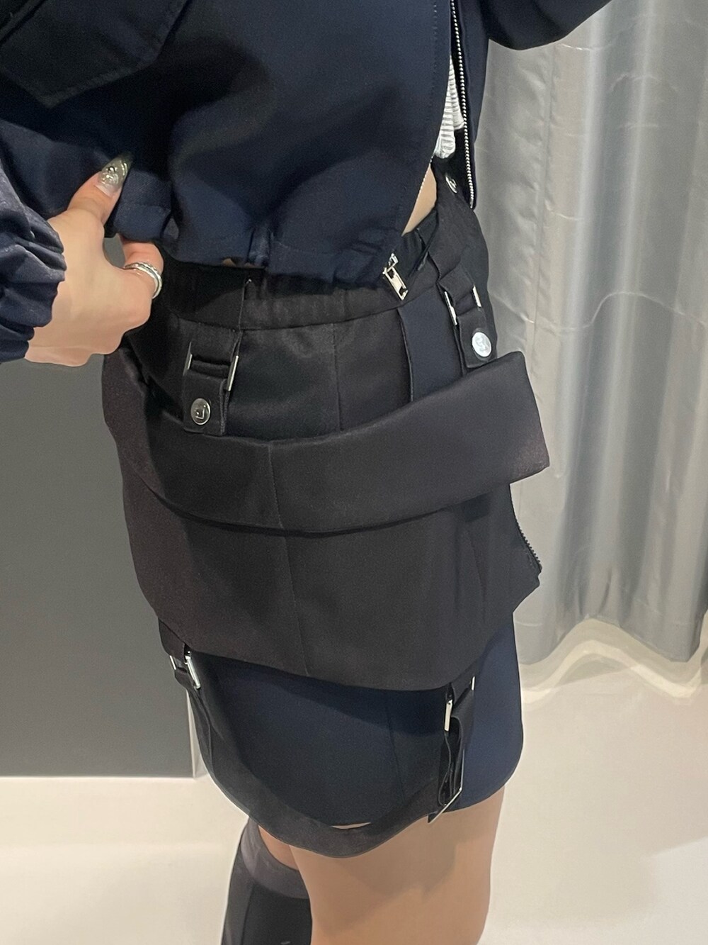 グレー系のニット/セーター、ブルー系のスカート、シルバー系のスニーカーを着用したレディースの冬コーディネートの9枚目の写真