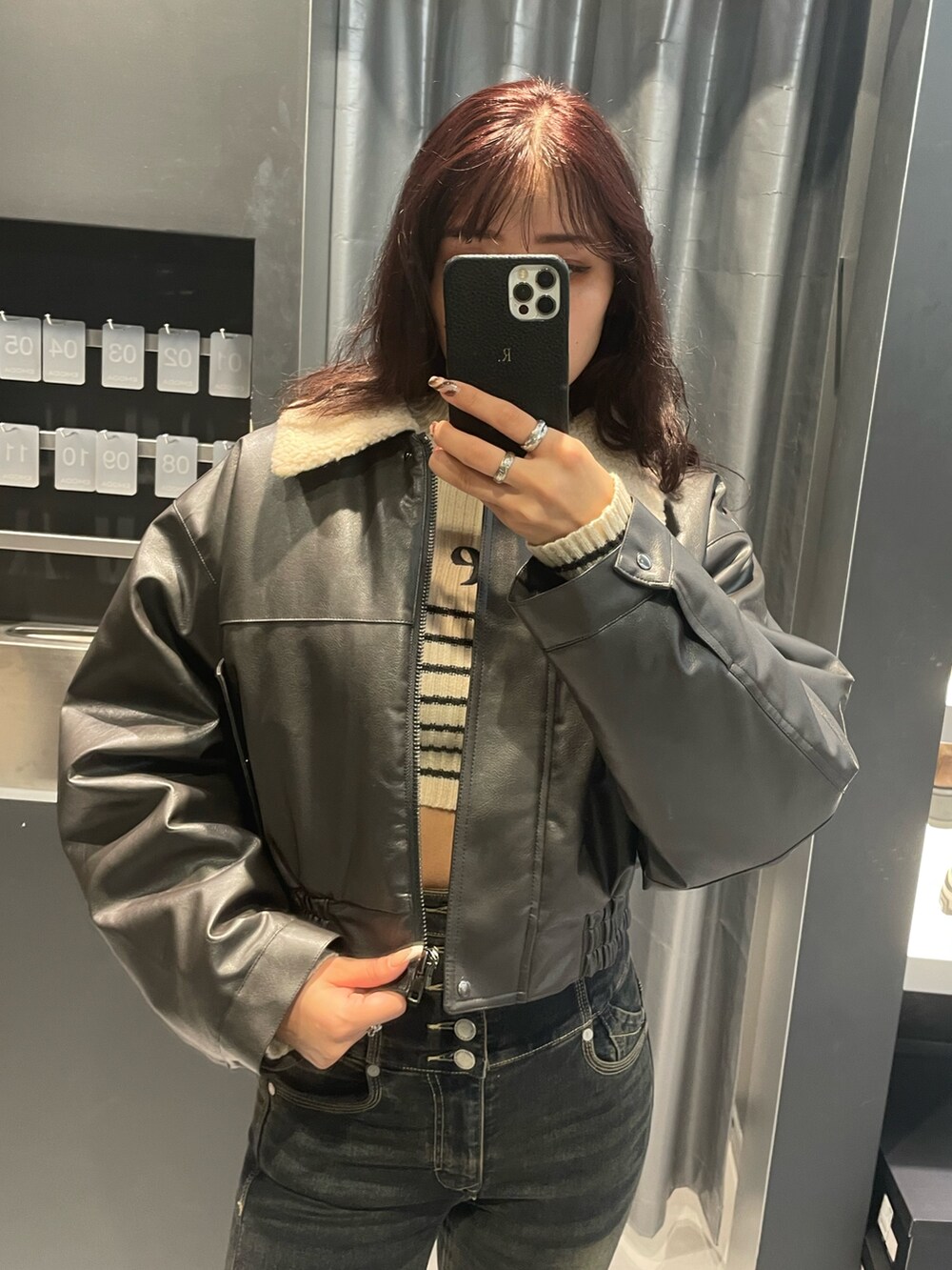 ホワイト系のニット/セーター、グレー系のブルゾン、ブルー系のデニムパンツを着用したレディースの秋コーディネートの4枚目の写真