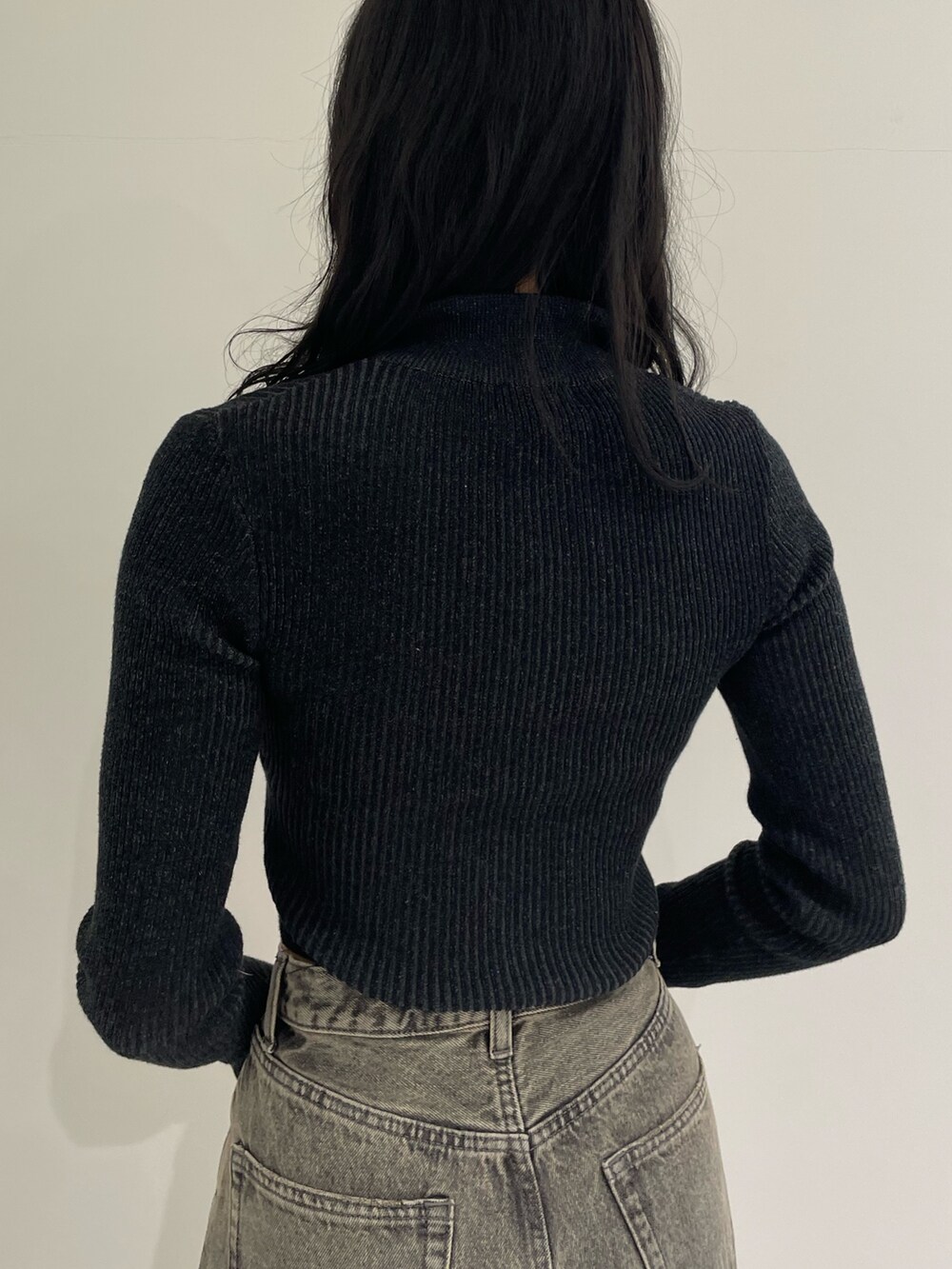 ブラック系のニット/セーター、グレー系のデニムパンツ、ブラック系のブーツを着用したレディースの春コーディネートの6枚目の写真
