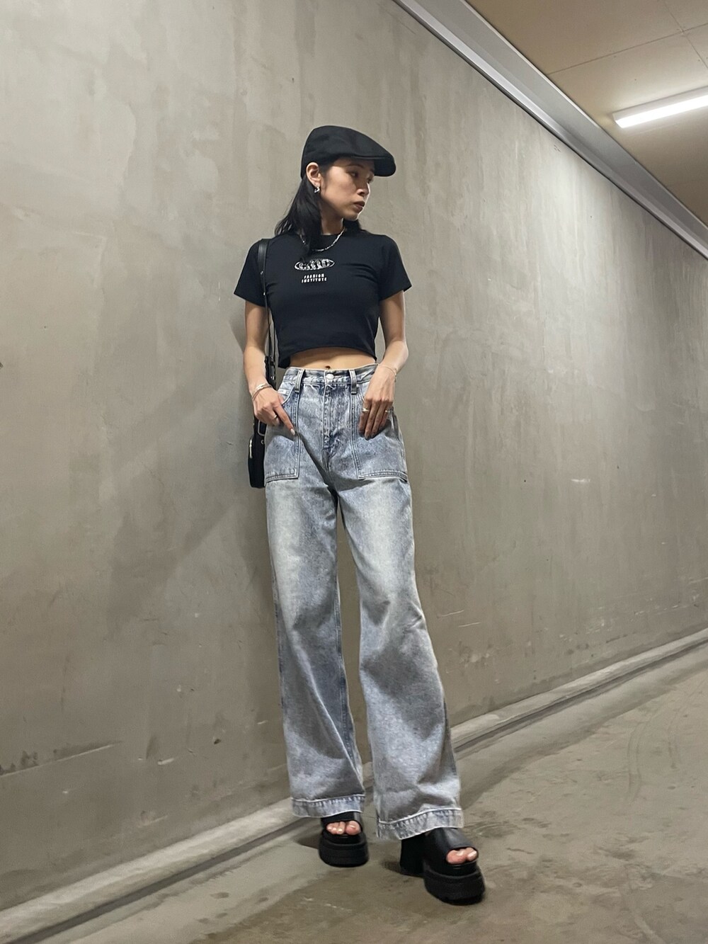 ブラック系のTシャツ/カットソー、ブラック系のショルダーバッグ、ブルー系のデニムパンツを着用したレディースの夏コーディネートの2枚目の写真