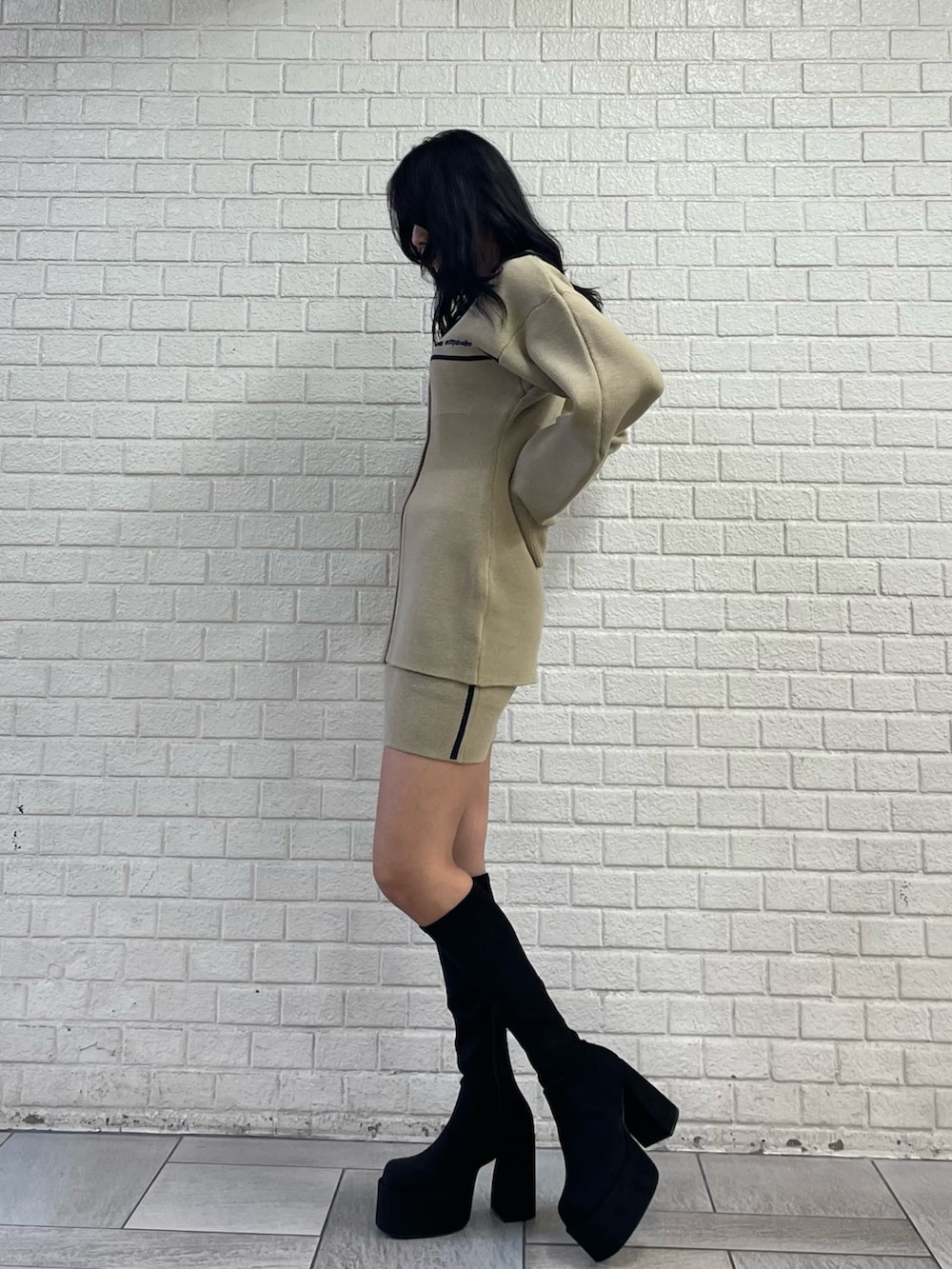 ベージュ系のカーディガン/ボレロ、ベージュ系のスカート、その他のブーツを着用したレディースの秋コーディネートの2枚目の写真