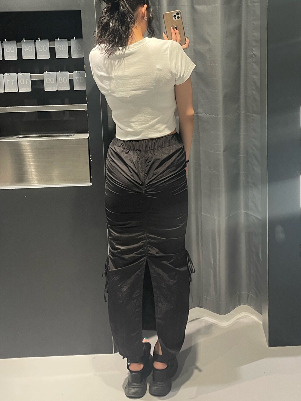 ホワイト系のTシャツ/カットソー、ブラック系のスカート、ブラック系のサンダルを着用したレディースの夏コーディネートの3枚目の写真