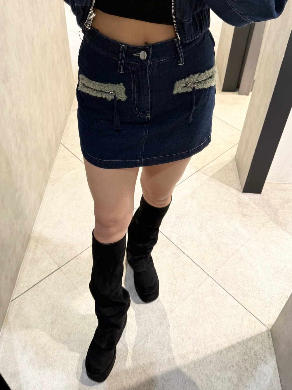 ブルー系のブルゾン、ブラック系のニット/セーター、ブルー系のスカートを着用したレディースの秋コーディネートの6枚目の写真