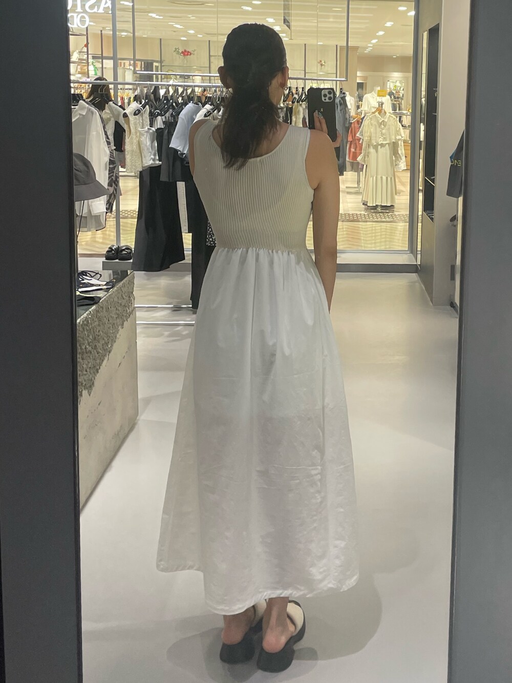 ホワイト系のワンピース、ホワイト系のサンダル、シルバー系のネックレスを着用したレディースの夏コーディネートの5枚目の写真