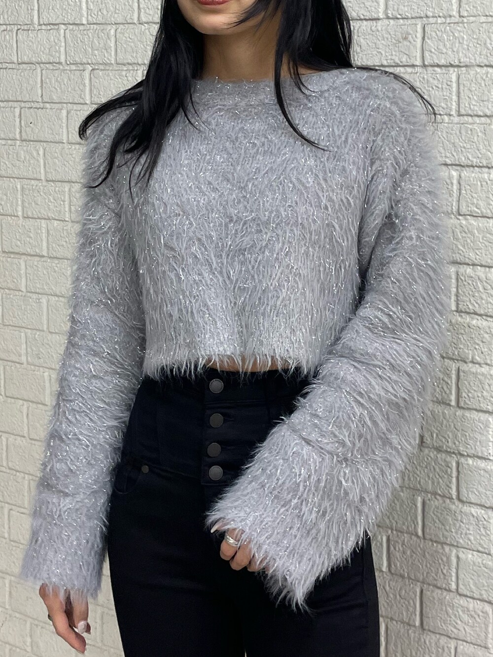 グレー系のニット/セーター、ブラック系のデニムパンツ、ブラック系のブーツを着用したレディースの冬コーディネートの4枚目の写真