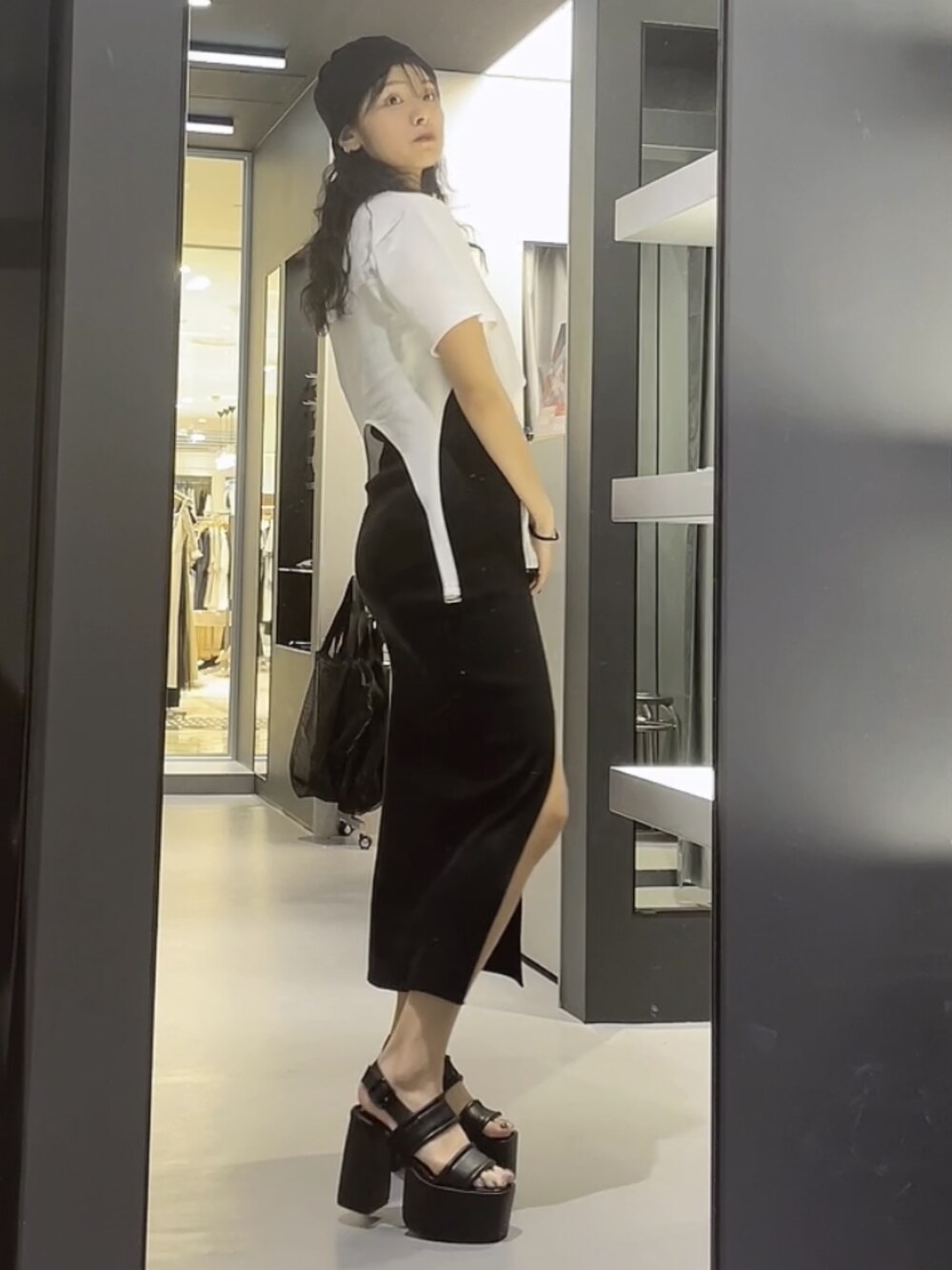 ホワイト系のTシャツ/カットソー、ブラック系のワンピース、ブラック系のサンダルを着用したレディースの夏コーディネートの2枚目の写真