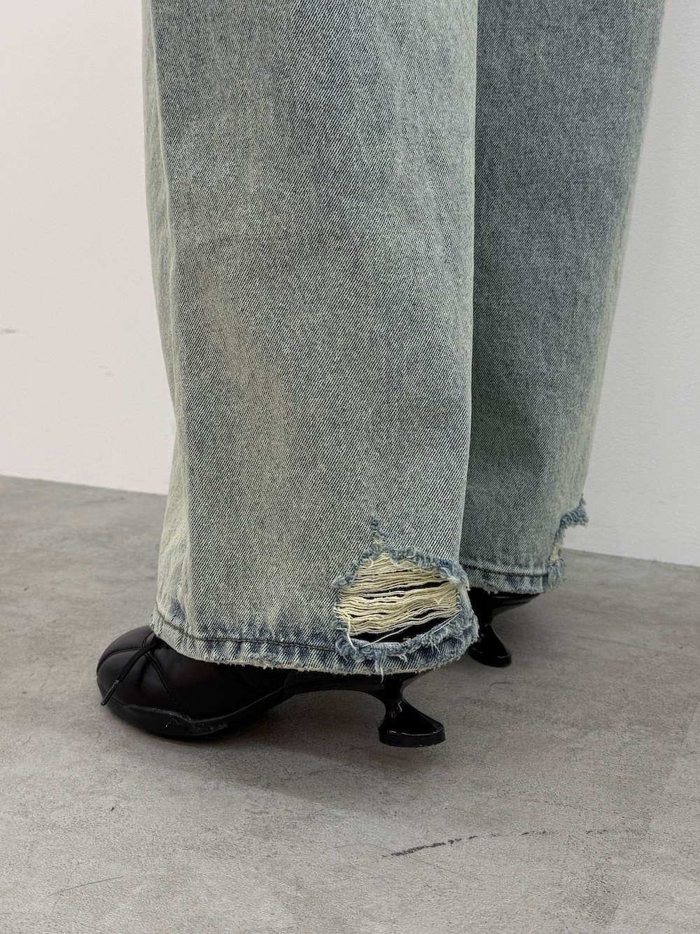 ブラック系のブルゾン、ホワイト系のTシャツ/カットソー、ブルー系のデニムパンツを着用したレディースの冬コーディネートの6枚目の写真