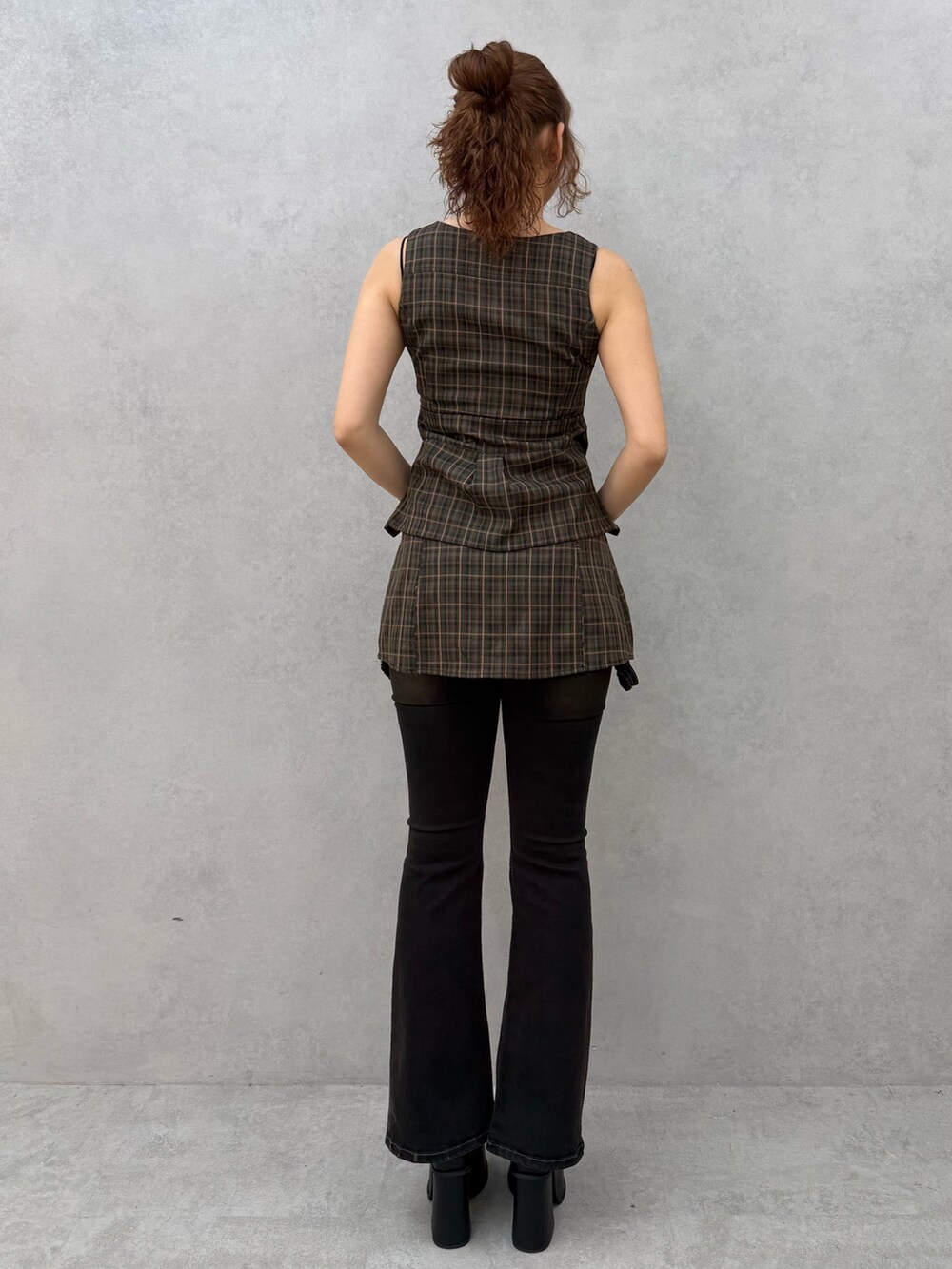 ブラウン系のワンピース、ブラック系のデニムパンツ、ブラック系のサンダルを着用したレディースの夏コーディネートの3枚目の写真