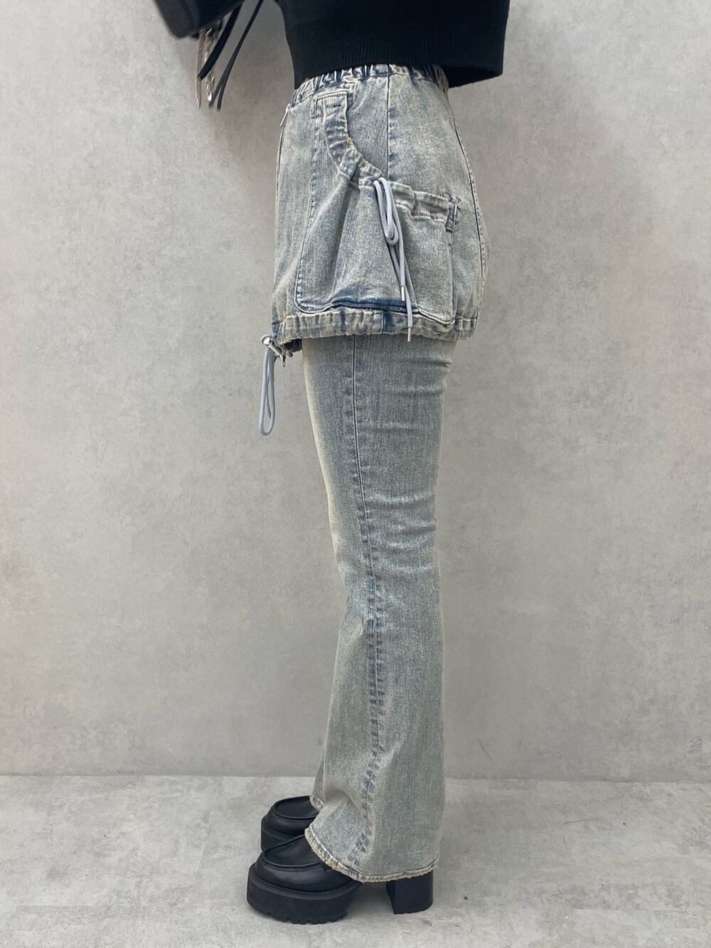 ブラック系のニット/セーター、ブルー系のデニムパンツ、ブラック系のショルダーバッグを着用したレディースの夏コーディネートの8枚目の写真