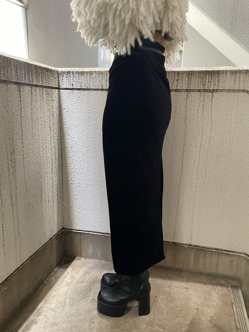 グレー系のニット/セーター、ブラック系のハンドバッグ、ブラック系のスカートを着用したレディースの秋コーディネートの8枚目の写真