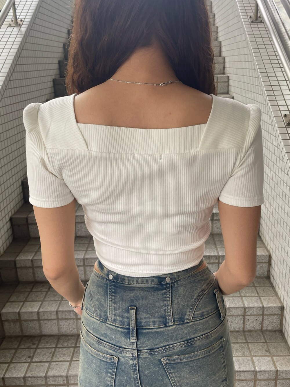 ホワイト系のTシャツ/カットソー、ブルー系のデニムパンツ、ブラック系のサンダルを着用したレディースの春コーディネートの6枚目の写真