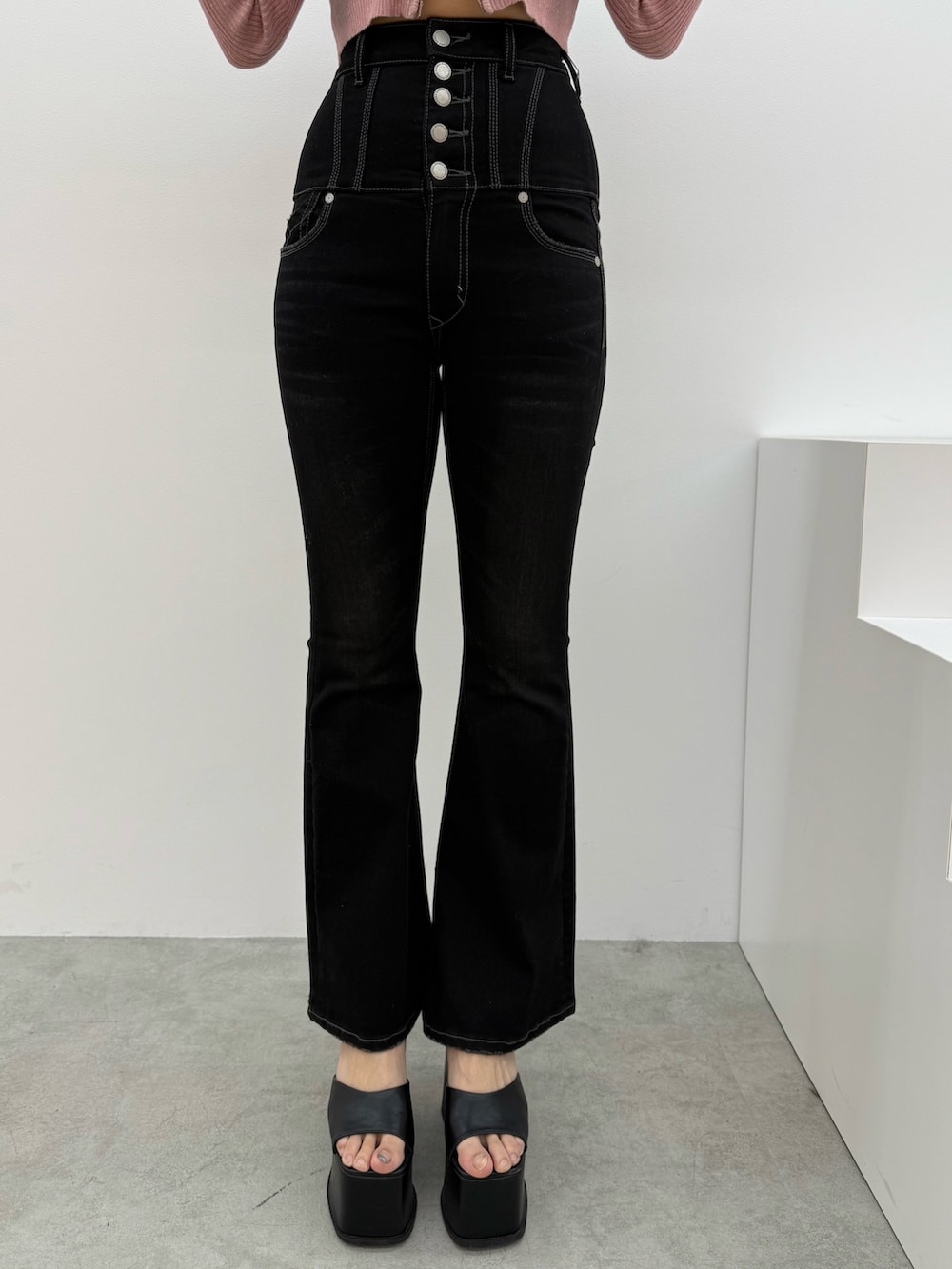 ピンク系のニット/セーター、ブラック系のデニムパンツ、ブラック系のサンダルを着用したレディースの冬コーディネートの4枚目の写真