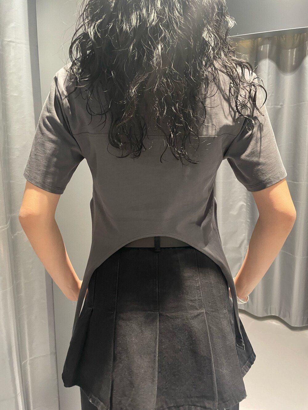 グレー系のTシャツ/カットソー、ブラック系のデニムスカート、ブラック系のデニムパンツを着用したレディースの春コーディネートの6枚目の写真