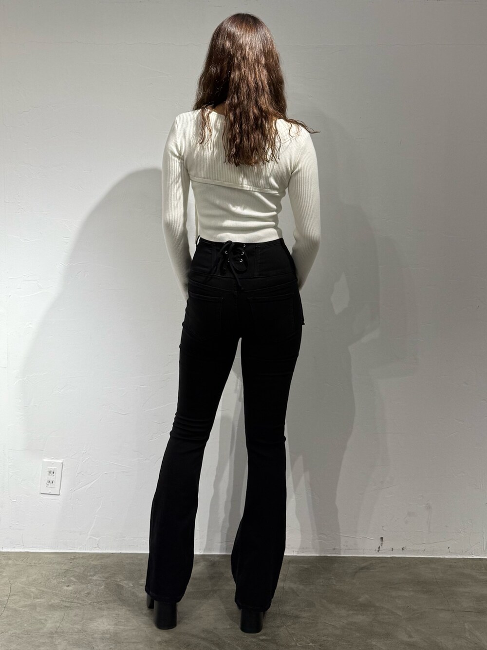 ホワイト系のニット/セーター、ブラック系のデニムパンツ、ブラック系のブーツを着用したレディースの秋コーディネートの3枚目の写真