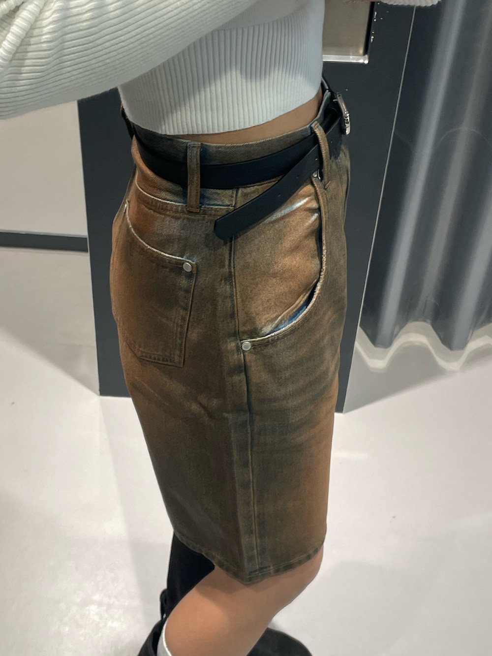 ホワイト系のニット/セーター、ブラウン系のデニムパンツ、ブラック系のブーツを着用したレディースの冬コーディネートの9枚目の写真