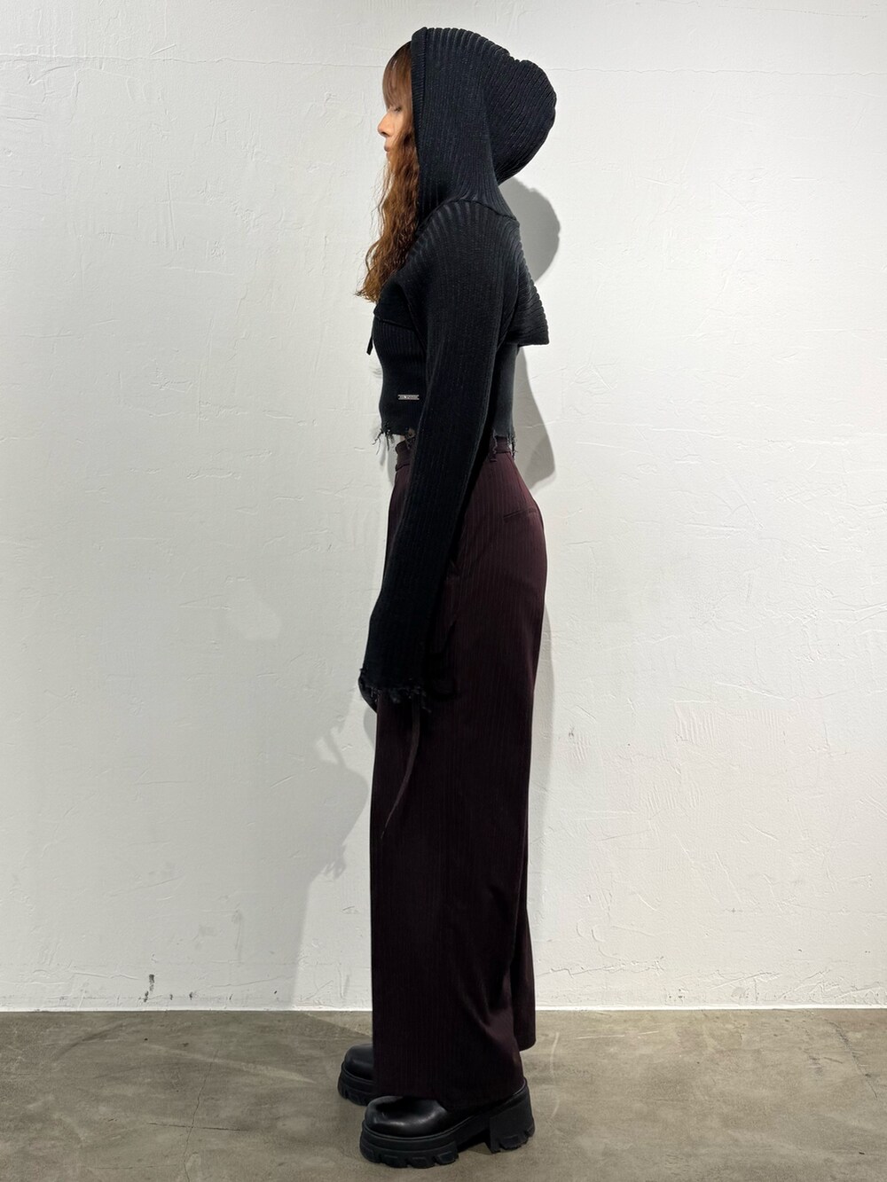 ブラック系のニット/セーター、ブラウン系のその他パンツ、ブラック系のハンドバッグを着用したレディースの秋コーディネートの2枚目の写真