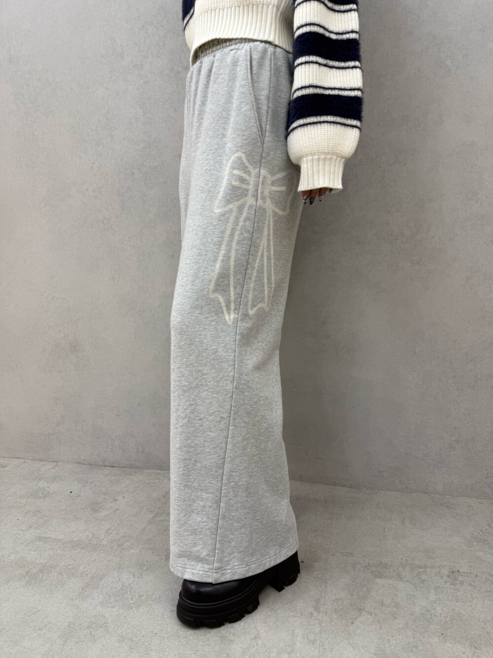 ブルー系のニット/セーター、グレー系のスウェットパンツ、ブラック系のブーツを着用したレディースの冬コーディネートの5枚目の写真