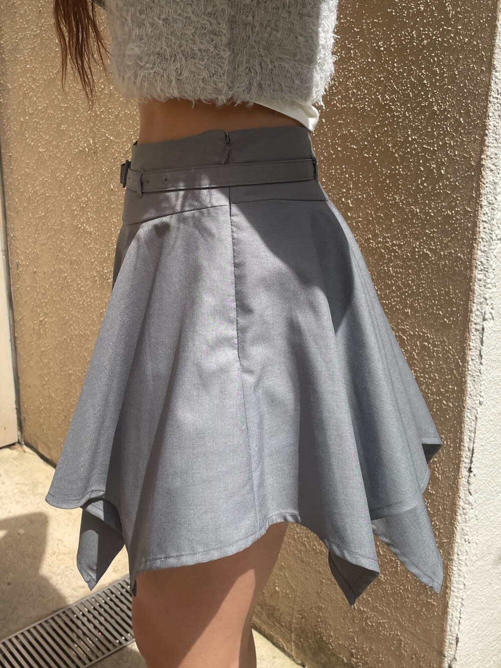 ホワイト系のTシャツ/カットソー、グレー系のニット/セーター、グレー系のスカートを着用したレディースの春コーディネートの6枚目の写真