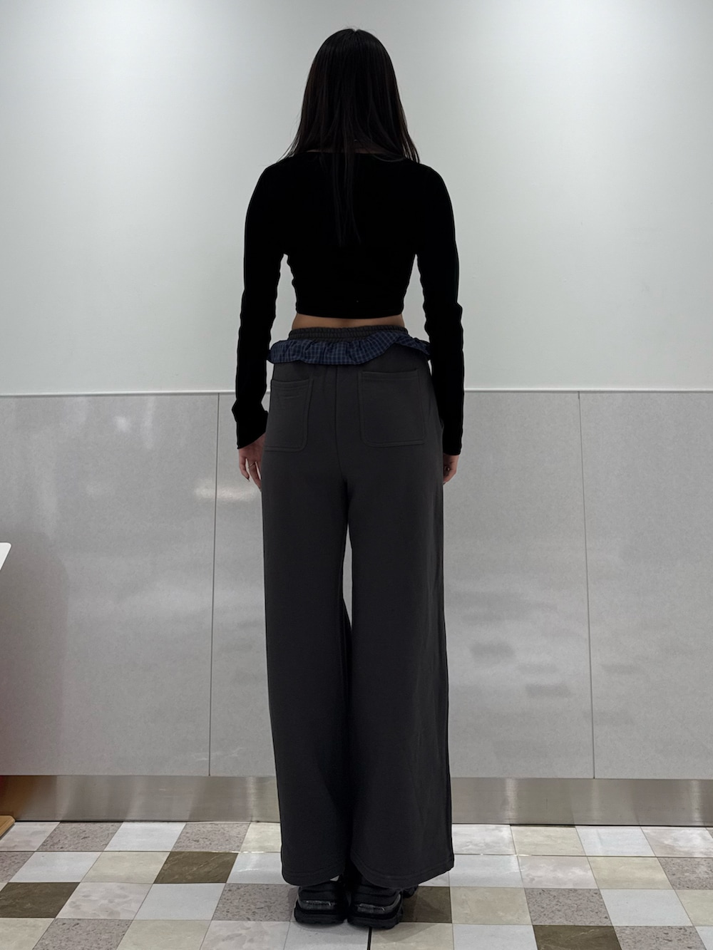 ブラック系のTシャツ/カットソー、グレー系のスウェットパンツ、ブラック系のスニーカーを着用したレディースの冬コーディネートの3枚目の写真