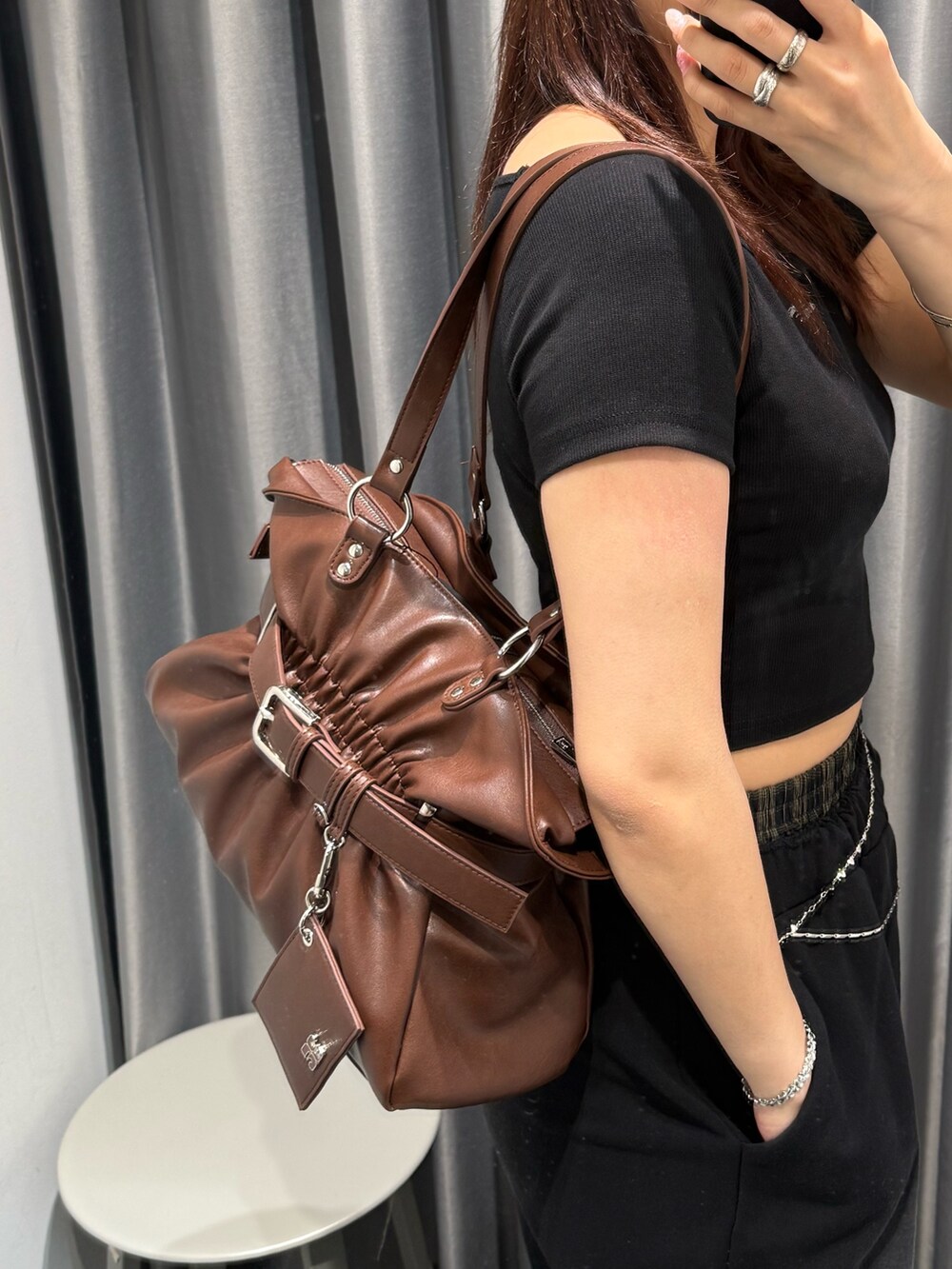ブラウン系のトートバッグ、ブラック系のスウェットパンツ、ブラック系のスニーカーを着用したレディースの春コーディネートの6枚目の写真