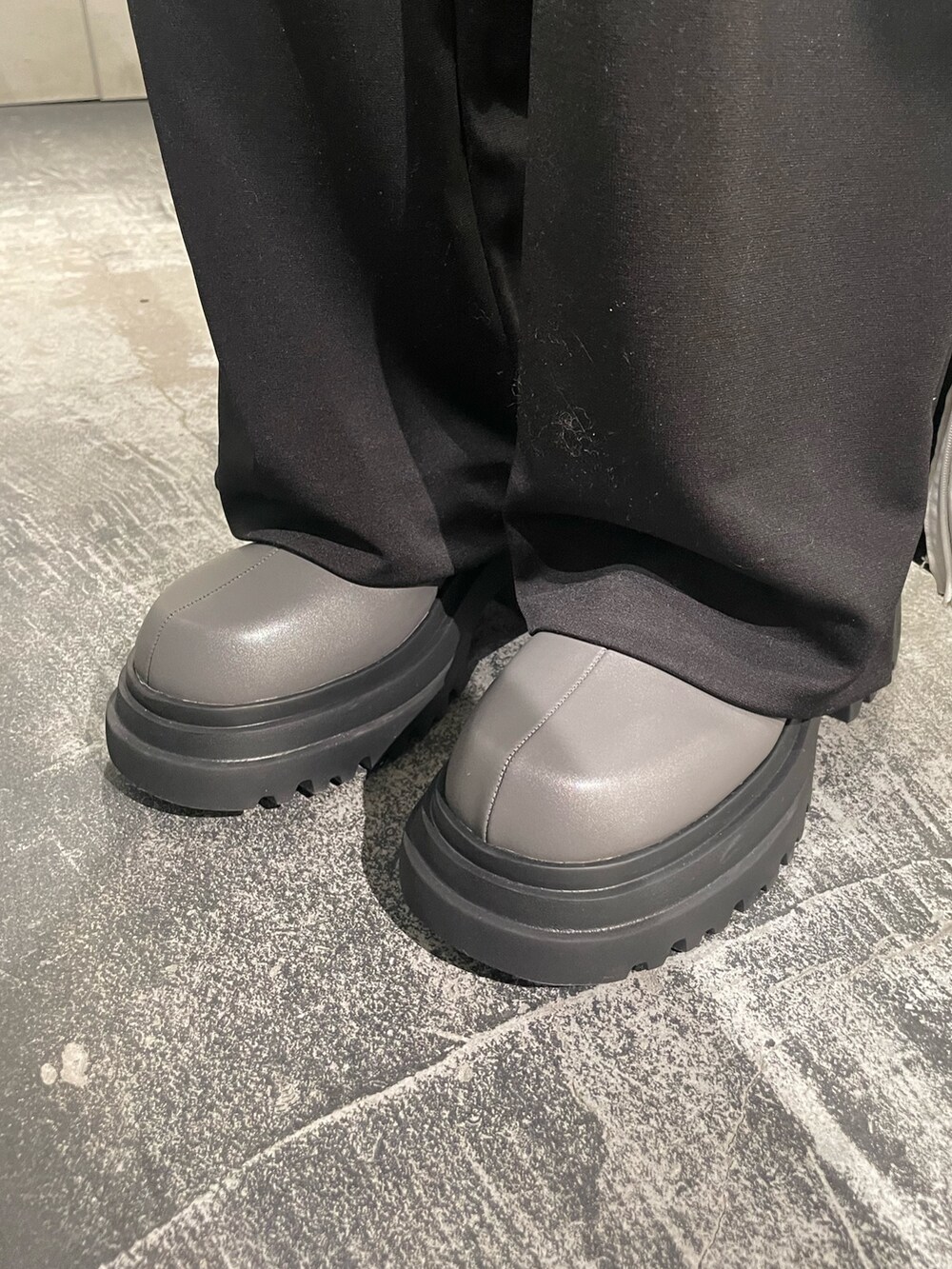 ブラック系のTシャツ/カットソー、ブラック系のスラックス、グレー系のブーツを着用したレディースの冬コーディネートの7枚目の写真