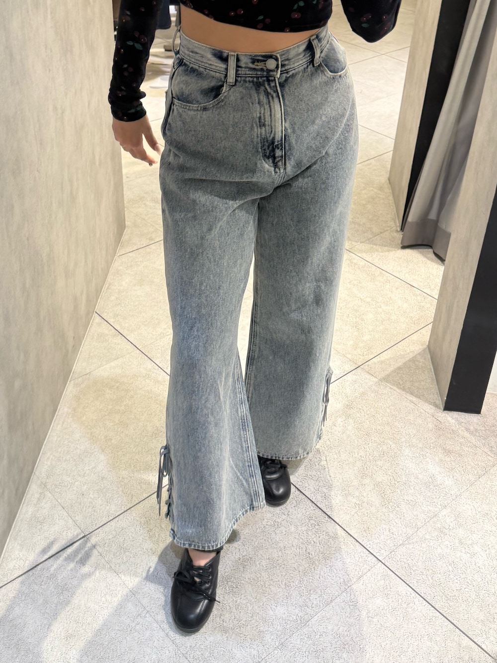 ブラック系のTシャツ/カットソー、ブルー系のデニムパンツ、ブラック系のスニーカーを着用したレディースの春コーディネートの5枚目の写真