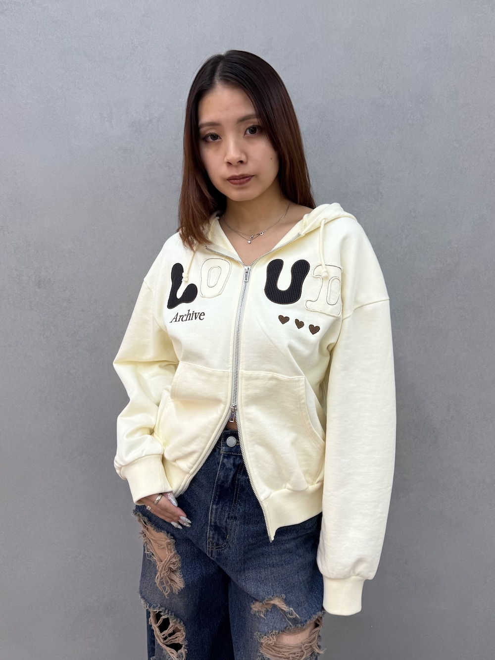 ホワイト系のパーカー、ブルー系のデニムパンツ、ブラック系のパンプスを着用したレディースの冬コーディネートの4枚目の写真