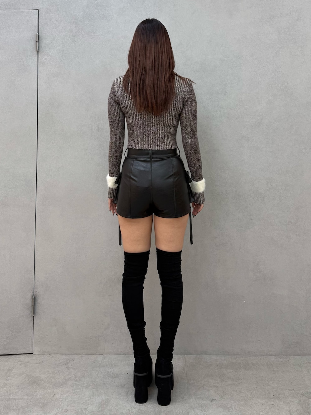 ブラウン系のニット/セーター、ブラック系のその他パンツ、ブラック系のブーツを着用したレディースの冬コーディネートの3枚目の写真