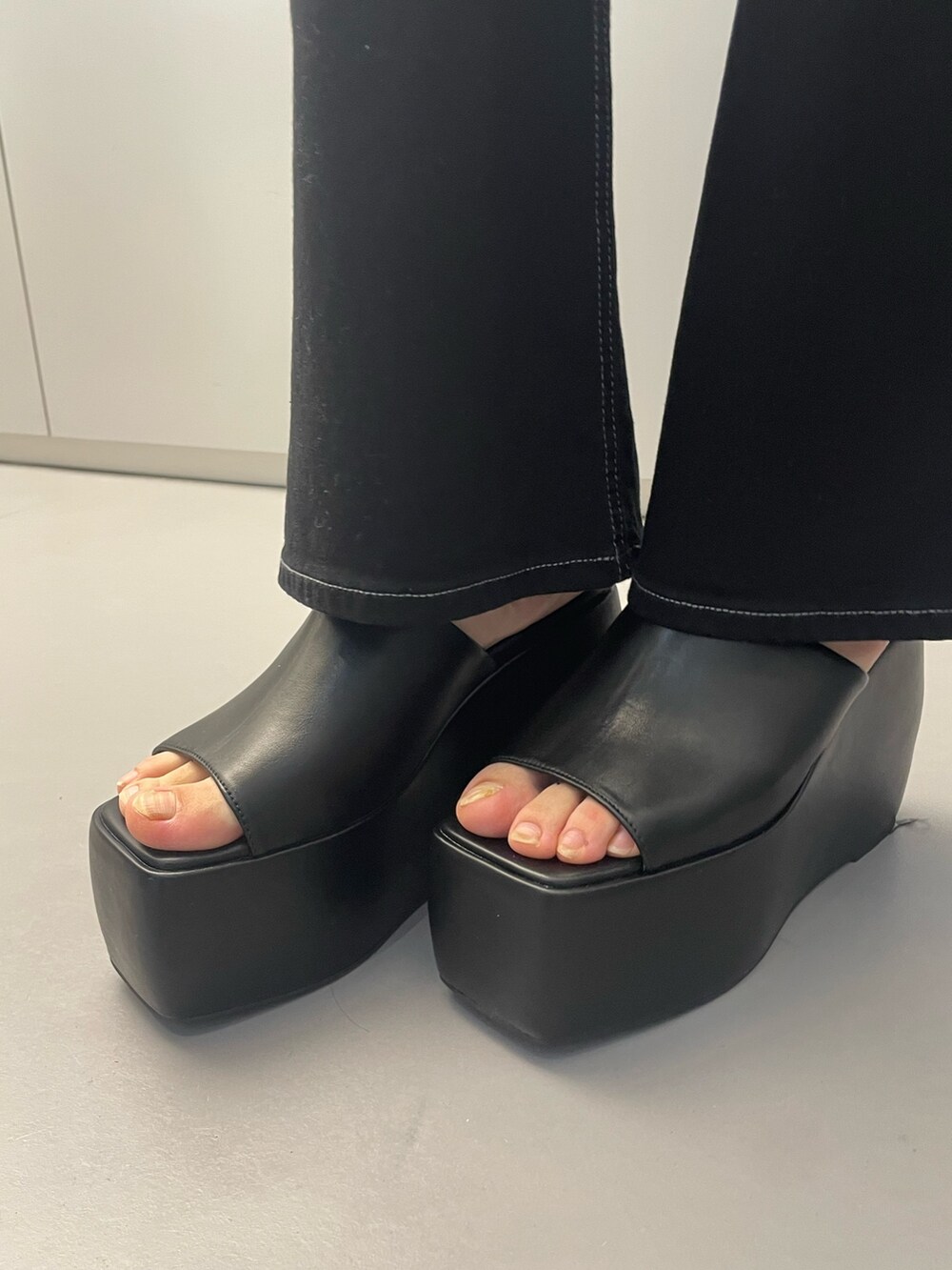 ブラック系のハンドバッグ、グレー系のワンピース、ブラック系のサンダルを着用したレディースの春コーディネートの9枚目の写真